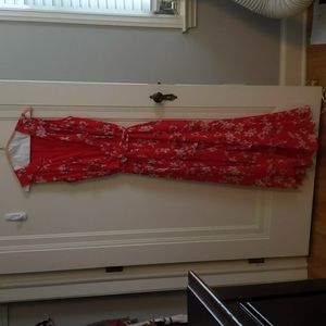 Beautiful red pattern ties at waist; dress with flowing details.